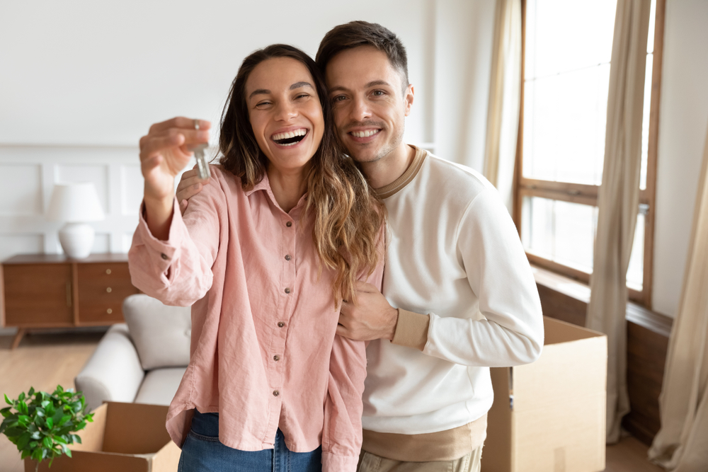 Happy couple smiling and holding house keys in their new home after a fast property sale in Vista, California – We Buy Houses Vista